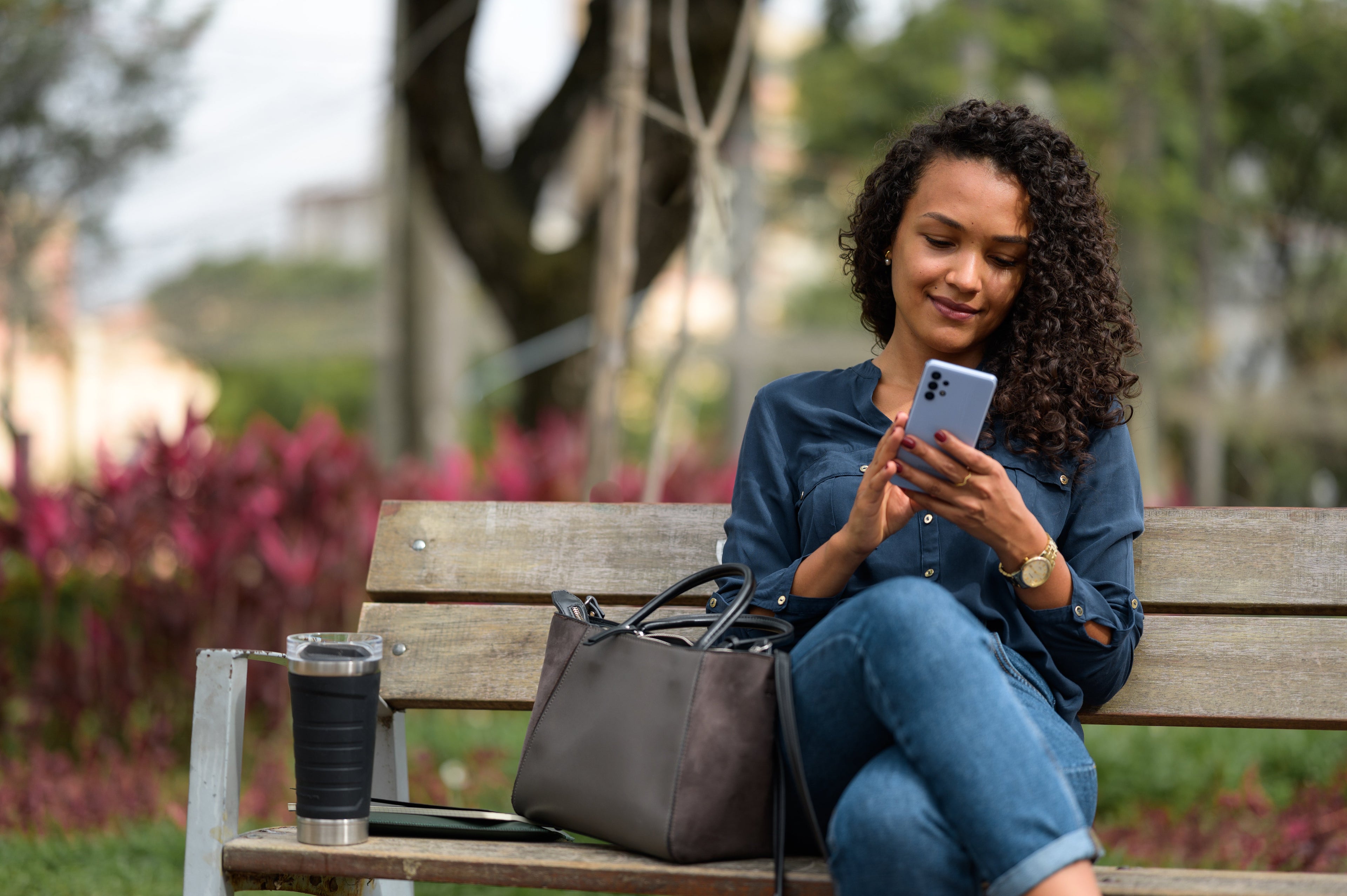 Woman browsing smartphone on a park bench